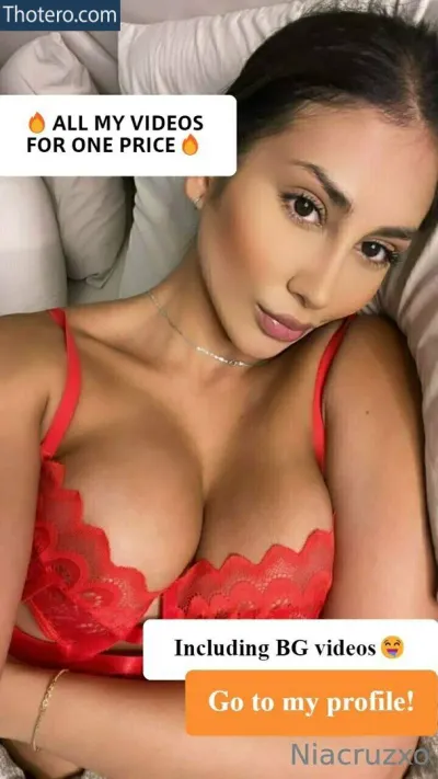 estefahg - a close up of a woman in a red bra top laying on a bed