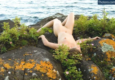 Brooke Lynne - woman laying on a rock with her bare body
