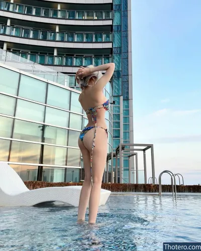 Vely.mom - woman in a bikini standing in a pool in front of a building