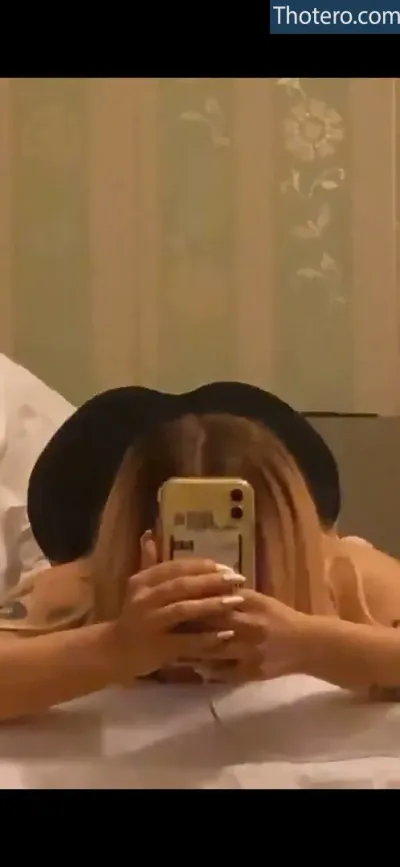 Demxxs - there is a woman laying on a bed taking a picture of herself