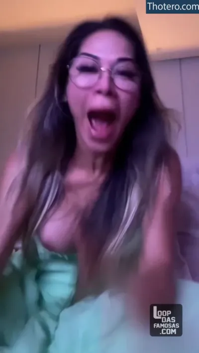 Maíra Cardi - woman in green dress with glasses making funny face while lying in bed