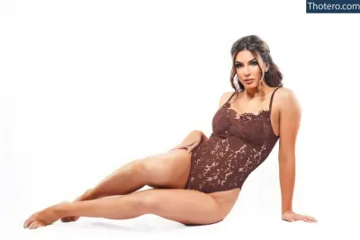 Cassie Lee - a close up of a woman in a brown bodysuit laying on the ground