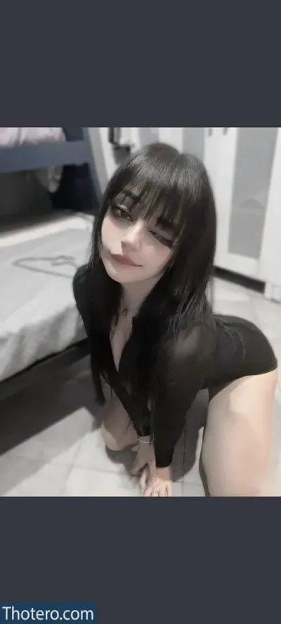 jadewaifu666 - a close up of a woman in a black dress sitting on a bed