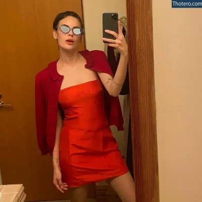 Tallulah Willis - woman in red dress taking selfie in mirror with red jacket