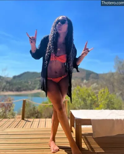 Alex Scott - woman in a bikini and jacket standing on a deck