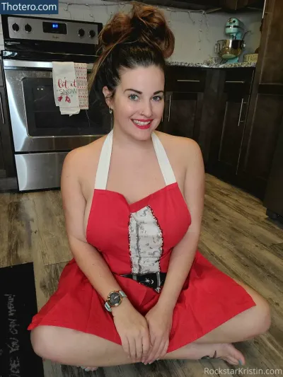 rockstarkristin - woman in red dress sitting on kitchen floor with a cake in her hand