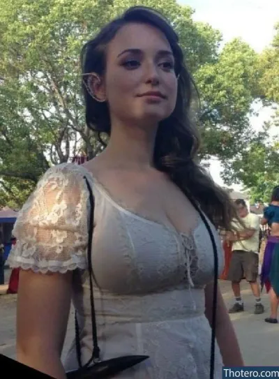 Milana Vayntrub - woman in a white dress with a camera in her hand