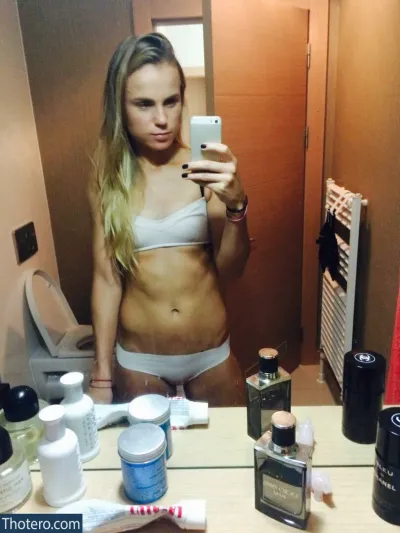 Lina Gecevicene - woman in a white bikini taking a selfie in a bathroom mirror