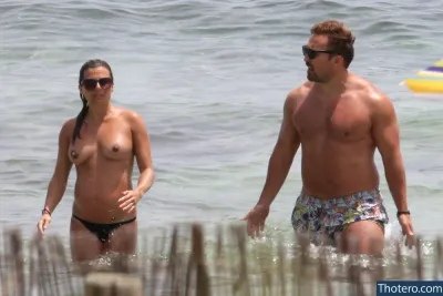 Zoe Hardman - in a bikini and a man in a bathing suit are walking in the water
