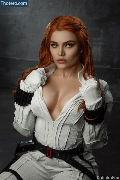 Christina Fink - a close up of a woman with red hair and a white suit