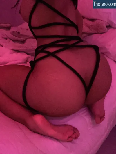 Scarlettfio Latina - woman in a black bikini laying on a bed
