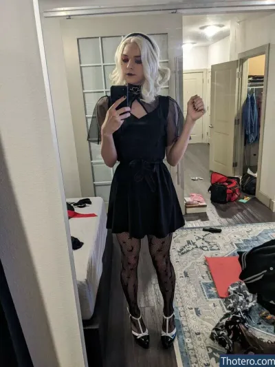 Wendy B. - blond woman in black dress taking selfie in mirror in bedroom