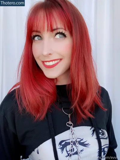 evvils - woman with red hair and a black shirt smiling