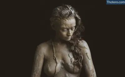 Marina Kushnir - woman with wet hair and no shirt standing in front of a black background