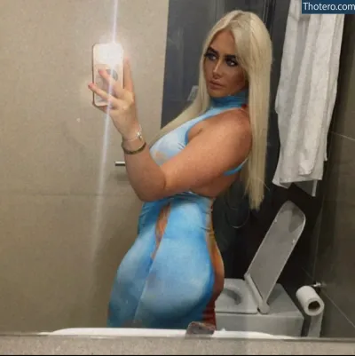 Jamie Lee - woman in blue dress taking a selfie in a bathroom mirror