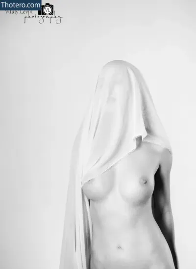 Sondra Lee - a black and white photo of a naked woman with a veil