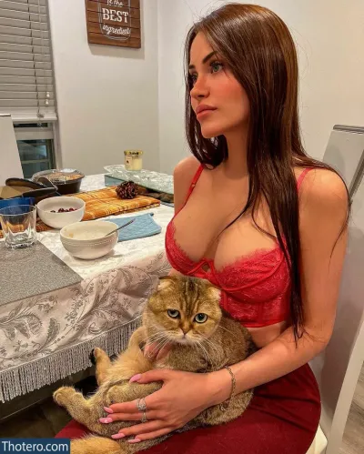 Claudia Alende - woman in red dress holding a cat in her lap