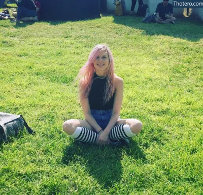May K - girl sitting on the grass in a black top and striped socks