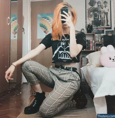Danna Alquati - girl with orange hair sitting on the floor taking a picture of herself