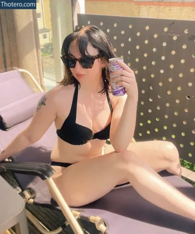 Femmeren - woman in black bikini sitting on a purple chair with a cell phone