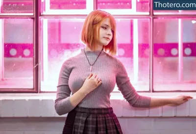 Smoettii - woman in a pink sweater and plaid skirt standing in front of a window