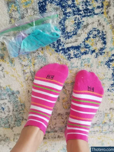 Goddess Rainn - someone is wearing pink socks and a pink bag of toothbrushes