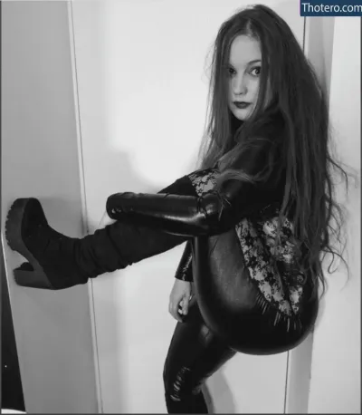 Octavius Kitten - woman in leather pants and boots leaning against a wall