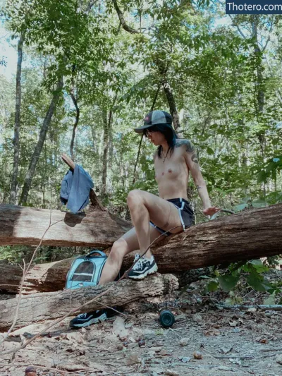 males_are_not_cancelled - there is a man sitting on a fallen tree in the woods