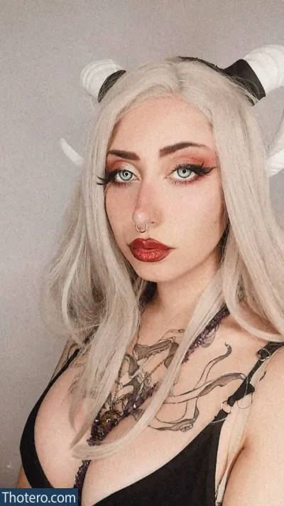 Evolet Asmr - blond woman with horns and piercings posing for a picture