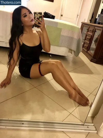 Ngyntlinh - woman sitting on the floor in a black dress taking a selfie