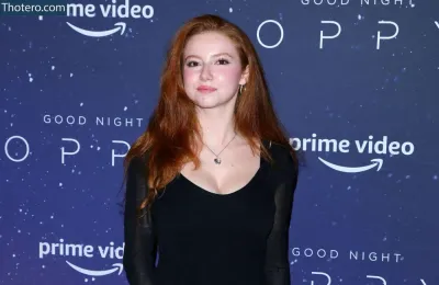 Francesca Capaldi - a woman in a black dress standing on a red carpet