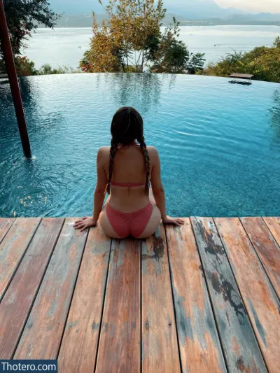 Ari Game Plays - woman sitting on a wooden deck overlooking a pool