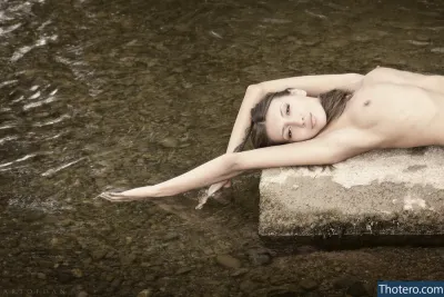 Saju90 - woman laying on a rock in a body of water