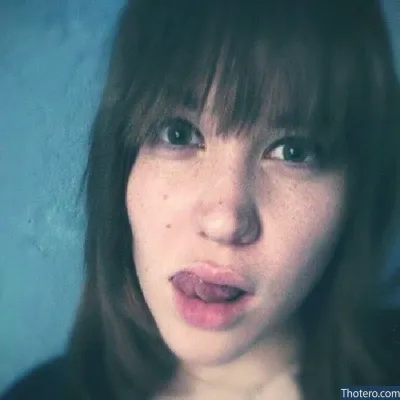 Aayley - woman with freckles on her face and a blue background