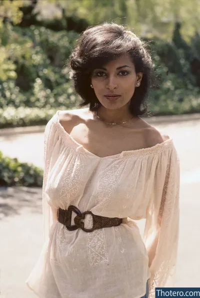 Pam Grier - woman in a white top and jeans posing for a picture