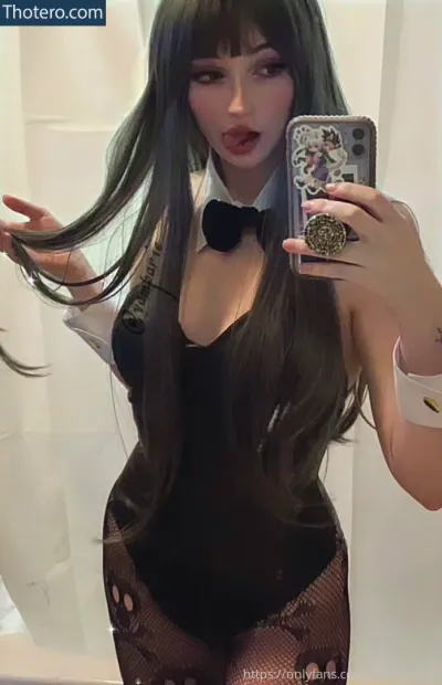 Vampariella - woman with long black hair taking a selfie in a black fishnet bodysuit