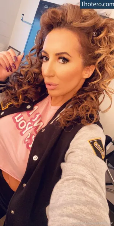 richelleryan - woman with long curly hair wearing a pink shirt and black jacket