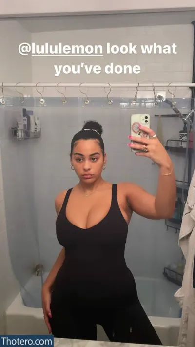 Raina Morris - woman taking a selfie in a bathroom mirror