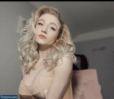 Janet Devlin - blond woman with long curly hair in a bra top posing for a picture