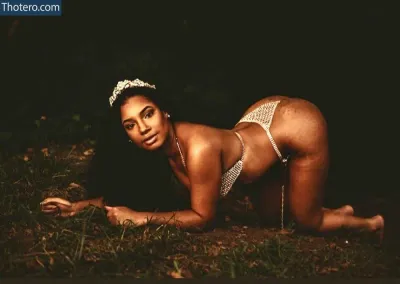 Tyaisha Neblett - woman in a bikini laying on the ground in the dark