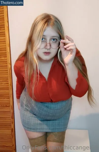 thiccangel69 - woman in glasses and a red shirt is holding a cell phone