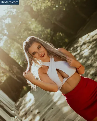 Rafaela Calza - woman in a white top and red skirt posing for a picture